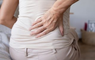 woman holding back in pain